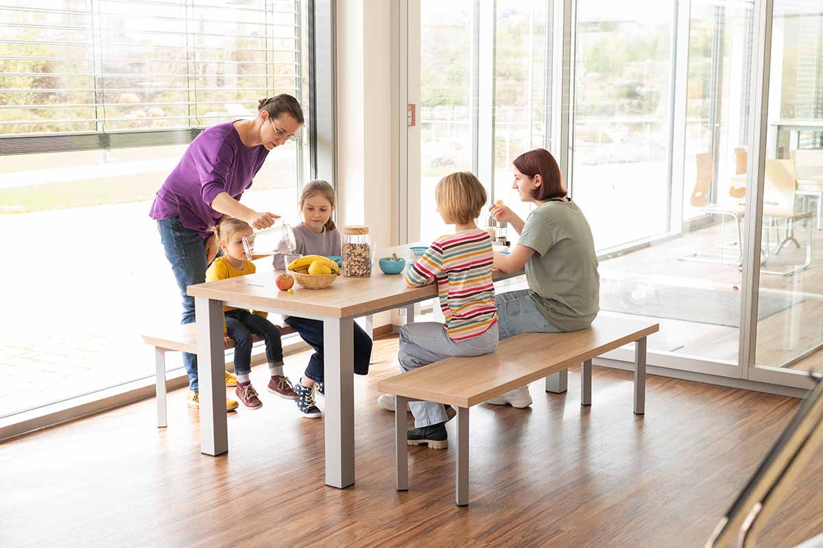 essBar Tisch und Bänke essBar Tisch und Bänke mit Familie mit Kindern beim Essen