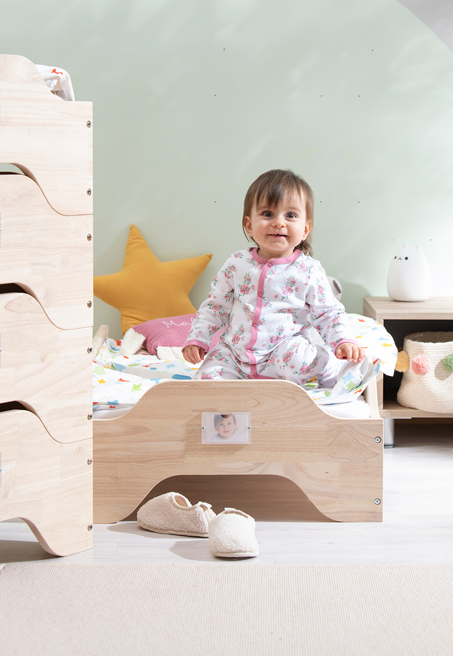 Stapelbares Kinderbett mit Bettwäsche und Kind
