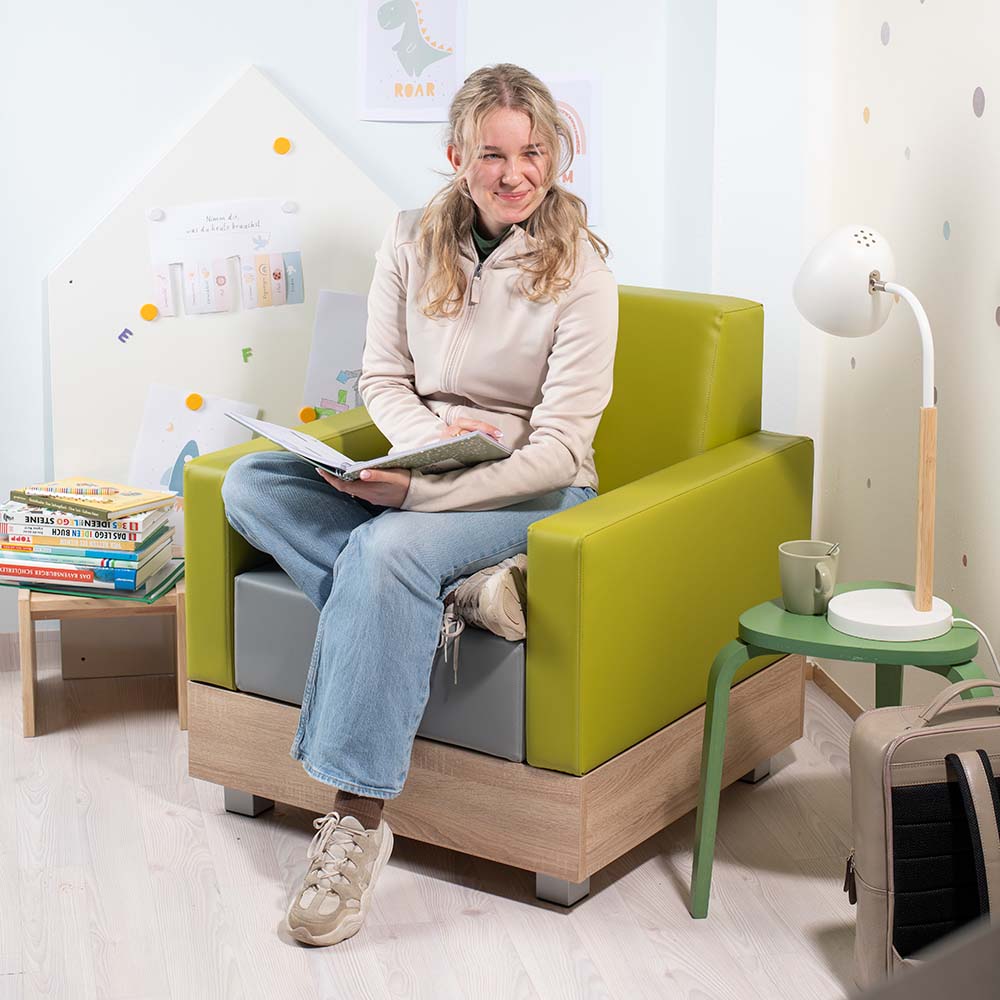 Chillo Sessel mit junger Frau, verschiedenen Büchern und Lampe in hellem Zimmer