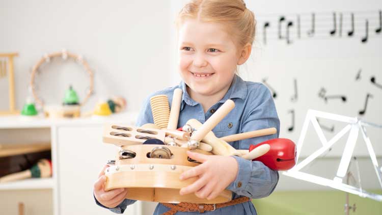 Mädchen mit Rhythmikinstrumenten im Arm