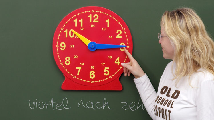 Lehrerin erklärt die Uhr mit der Betzold Lernuhr