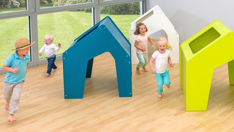 Kinder spielen zwischen Educasa Spielhäusern Nachlauf