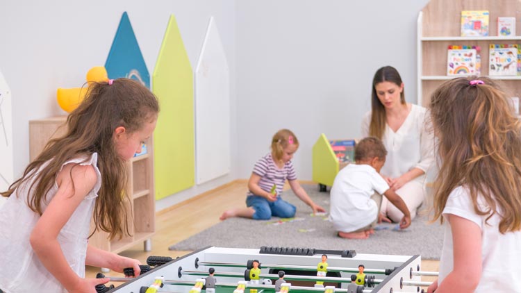 Kinder spielen im Kindergarten Tischkicker