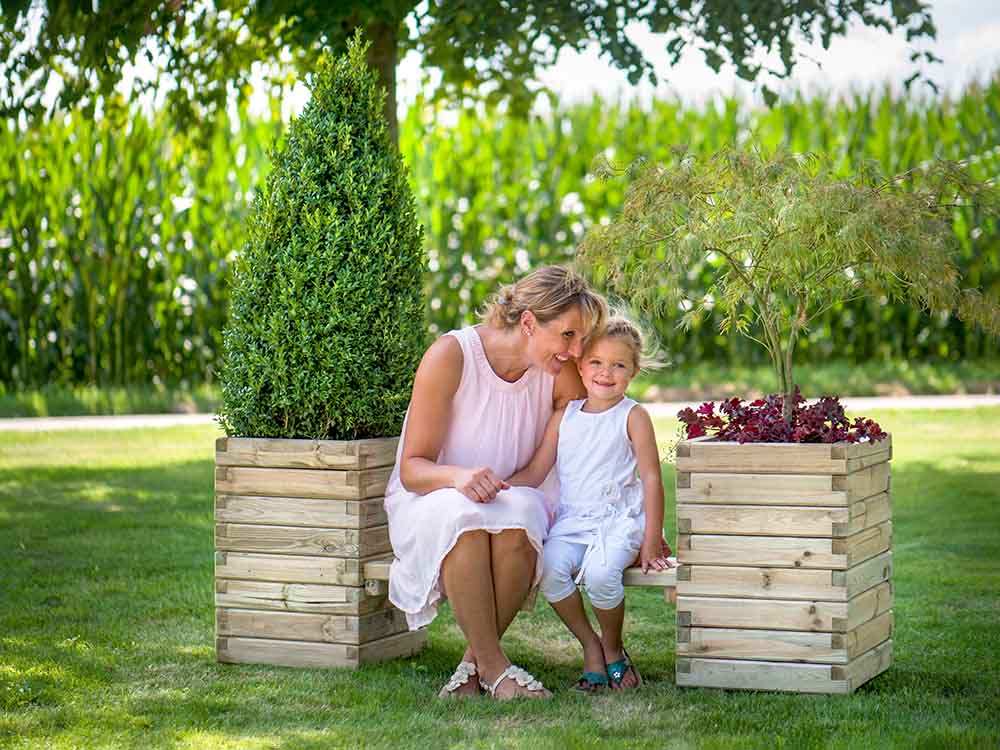Plantas Sitzkombination im Grünen mit Mutter und Tochter