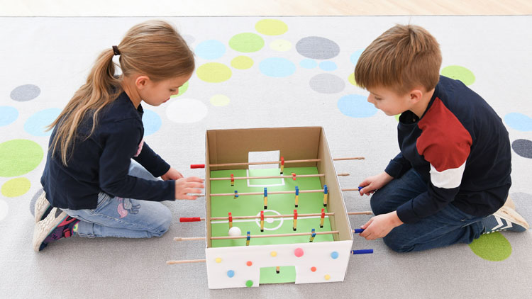 Kinder spielen mit Tischkicker
