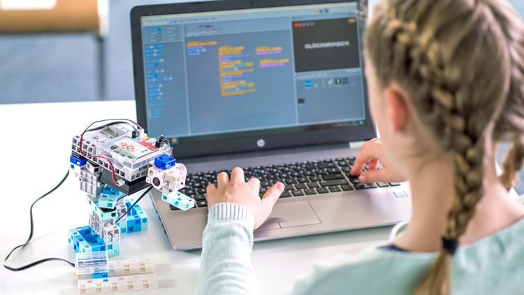Mädchen programmiert Roboter
