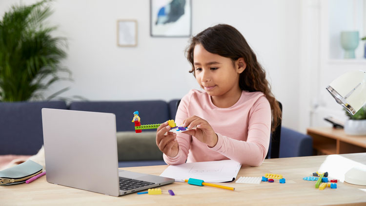Mädchen baut mit LEGO-Steinen