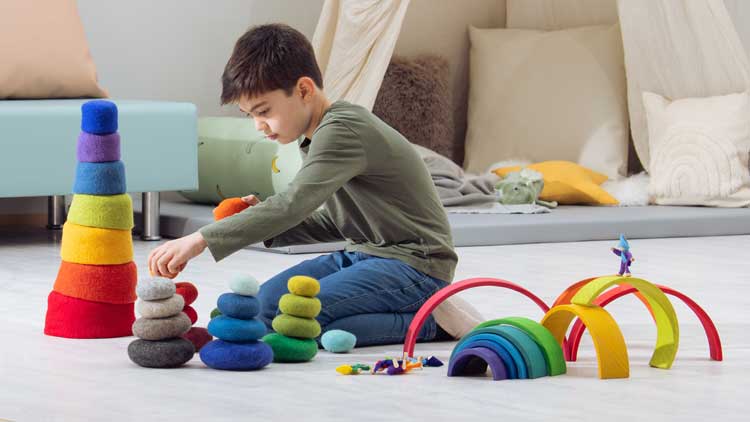 Farbenfrohe Stapelspiele können ebenso zur Montessori-Pädagogik gehören wie Spielzeug, das die Zahl-Zuordnung anregt.