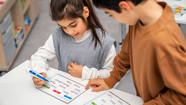 Kinder halten den Tellimero EDU an einen Sticker