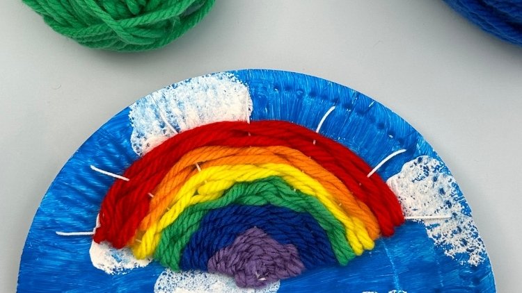 Gewebter Regenbogen auf einem Pappteller als Webrahmen.