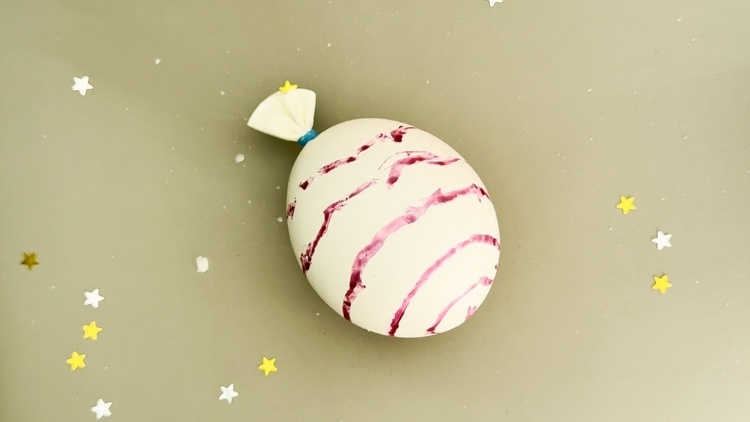 Ein mit Essig und Natron gefüllter Luftballon, der sich aufbläht.