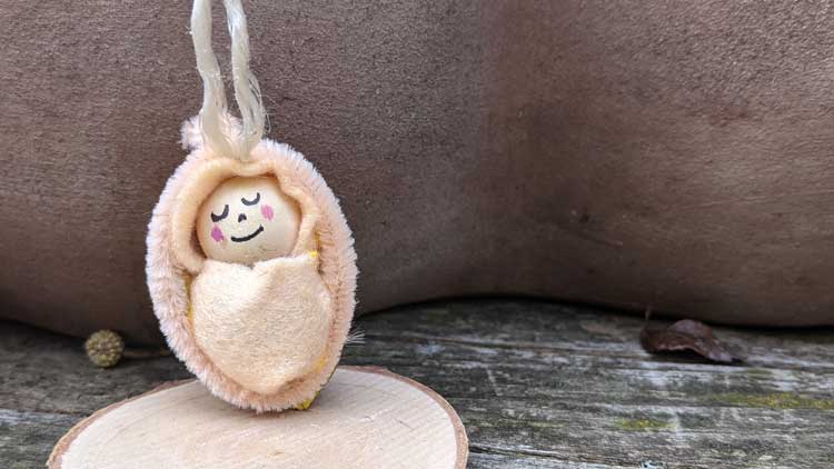 Bett mit einem Baby aus einer Walnussschale gebastelt.