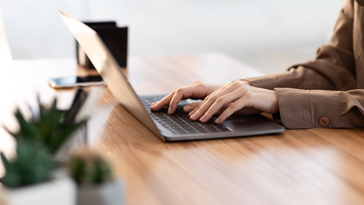 Frau schreibt auf Laptop