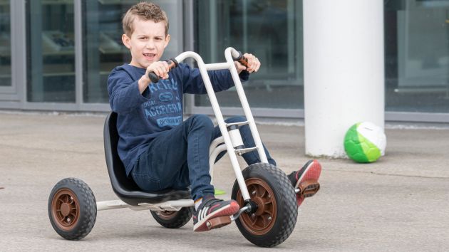 Junge auf Fahrzeug im Hof