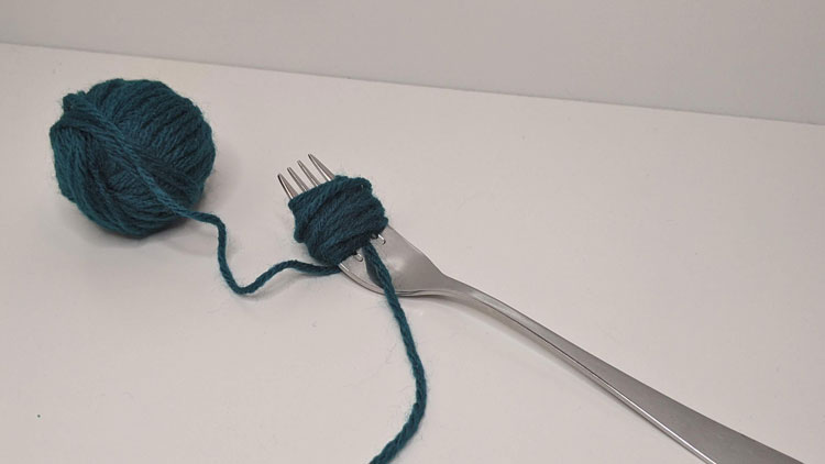Wolle aus dem Betzold Online-Shop um eine Gabel gewickelt.