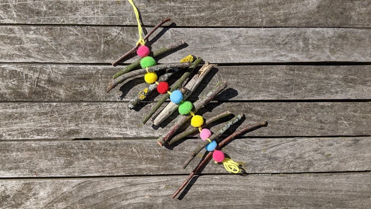 Pompons und Äste zu einem Windspiel verbastelt.
