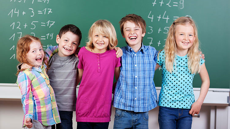 Kinder stehen vor Tafel