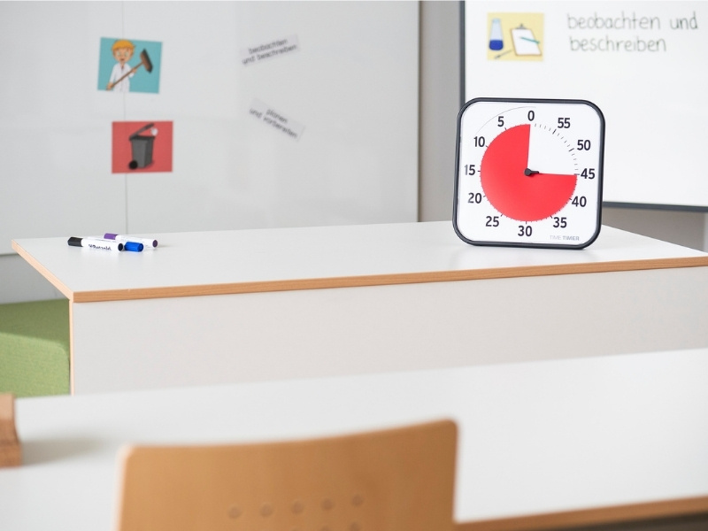 Time Timer steht auf dem Pult vor einer Tafel