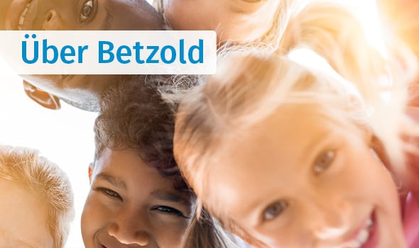 Kinder stecken die Köpfe zusammen und lachen in die Kamera