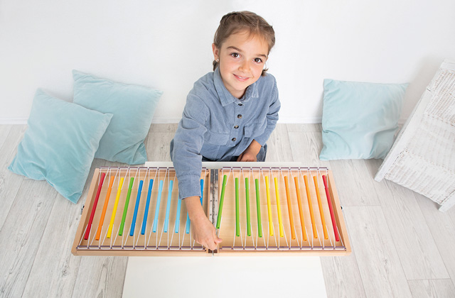 Kind macht mit dem Klangkoffer von beleduc Musik