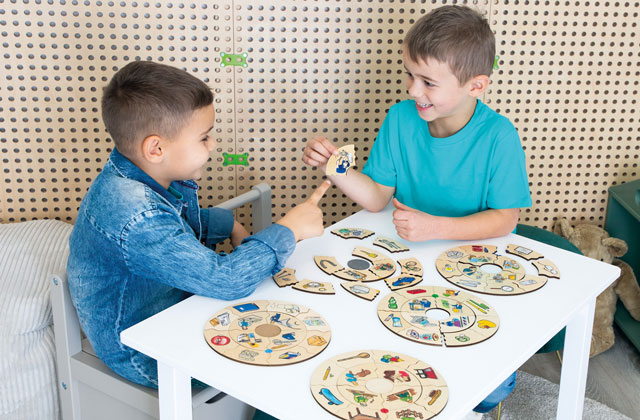 Kinder sitzen am Tisch und puzzeln