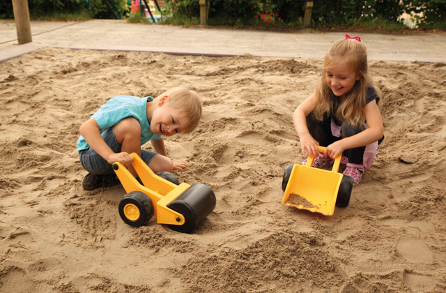 Kinder spielen mit Sandspielzeug im Sandkasten