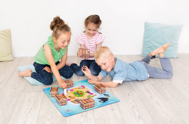 Kinder sitzen auf dem Boden und spielen ein Brettspiel
