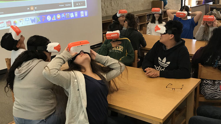 Kinder am Tisch mit aufgesetzten VR-Brillen
