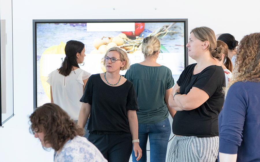 DIGIBIZ-Trainerin spricht mit mehreren Teilnehmerinnen über  Grafik auf einem Bildschirm