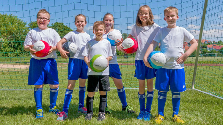 Schüler stehen vor Fußballtor