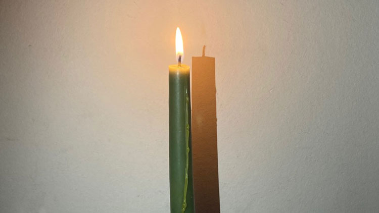 Kerze wird von Taschenlampe angestrahlt