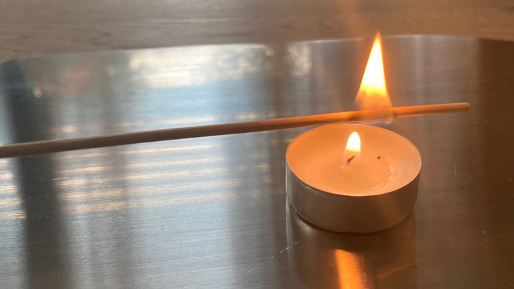 Kerzenflamme springt auf Holzstäbchen über
