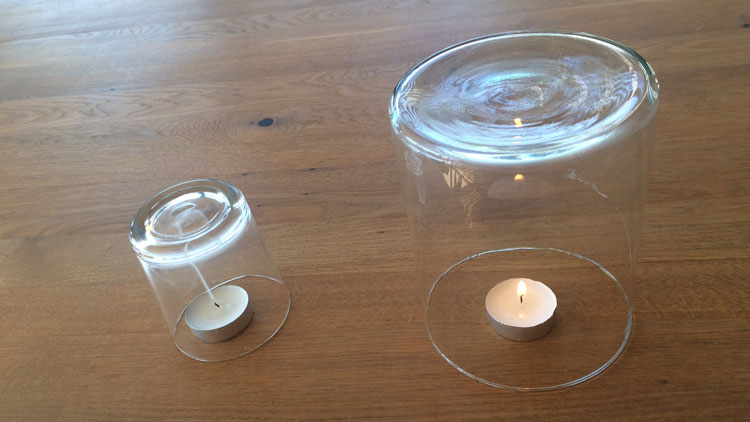Die Flamme unter dem kleineren Glas erlischt zuerst.