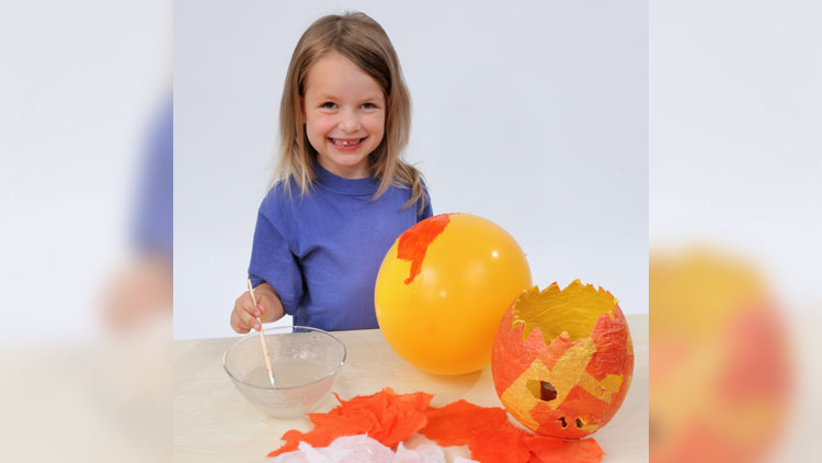 Kind bastelt Halloween-Laterne