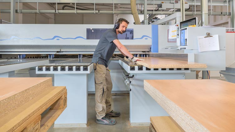 Ein Mitarbeiter arbeitet mit Holz
